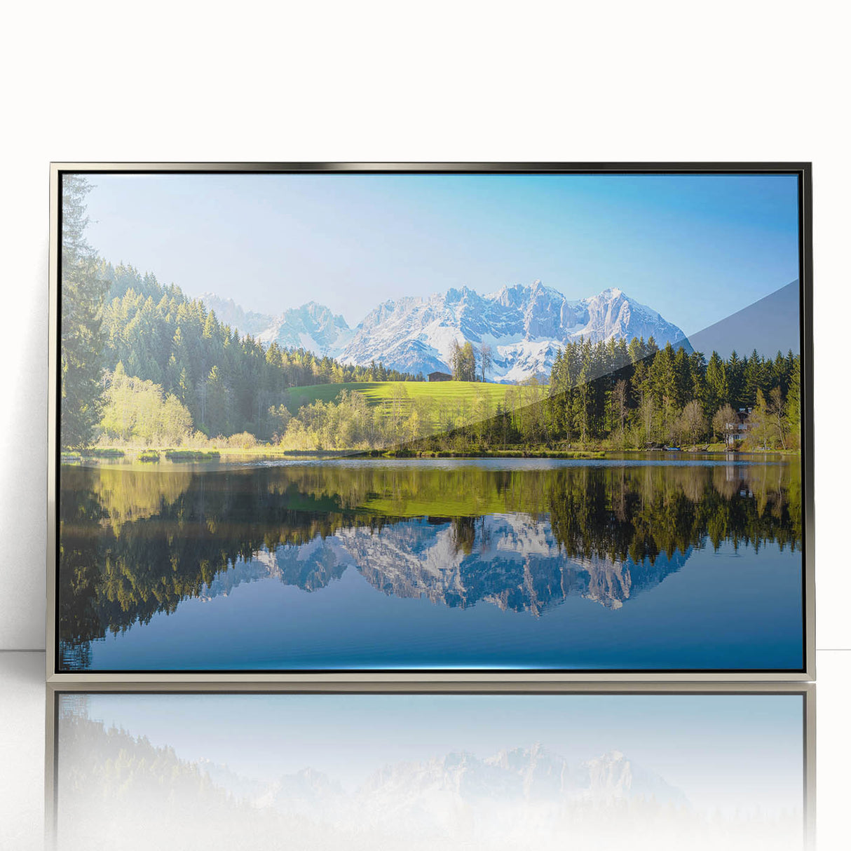 Large art print of a serene Austrian landscape in muted green and blue tones, framed in silver acrylic.