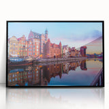 Large abstract wall art featuring a mid-century modernist design of a European cityscape in muted colors on a framed acrylic.