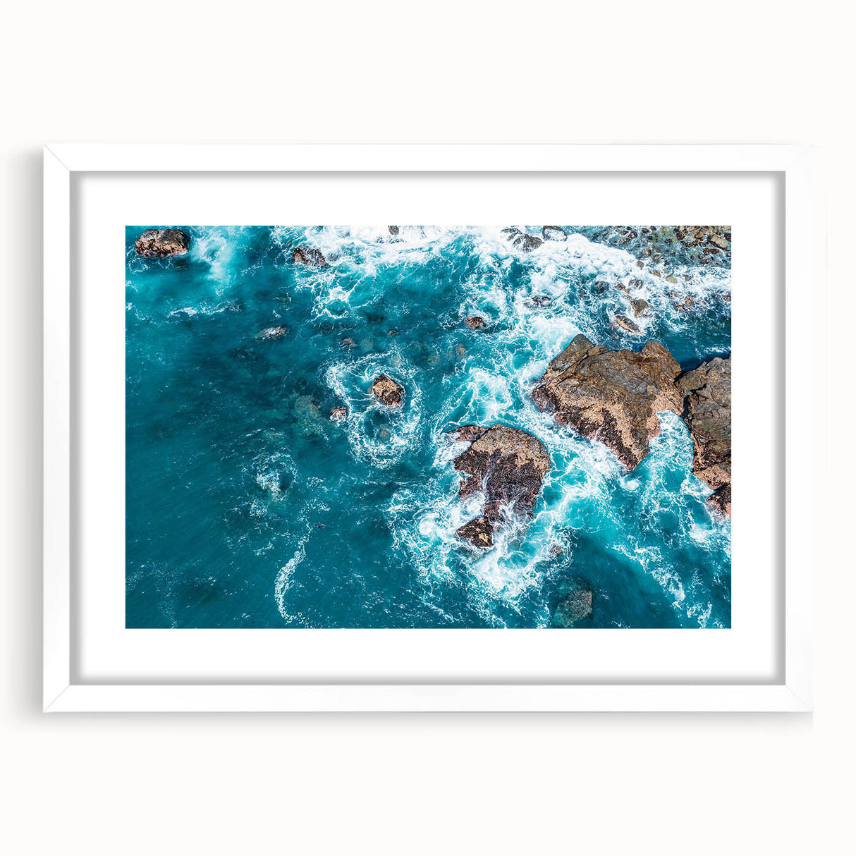 Abstract art print of Big Sur coastline in muted blue and green tones on a framed white mat, ideal for dining room decor.