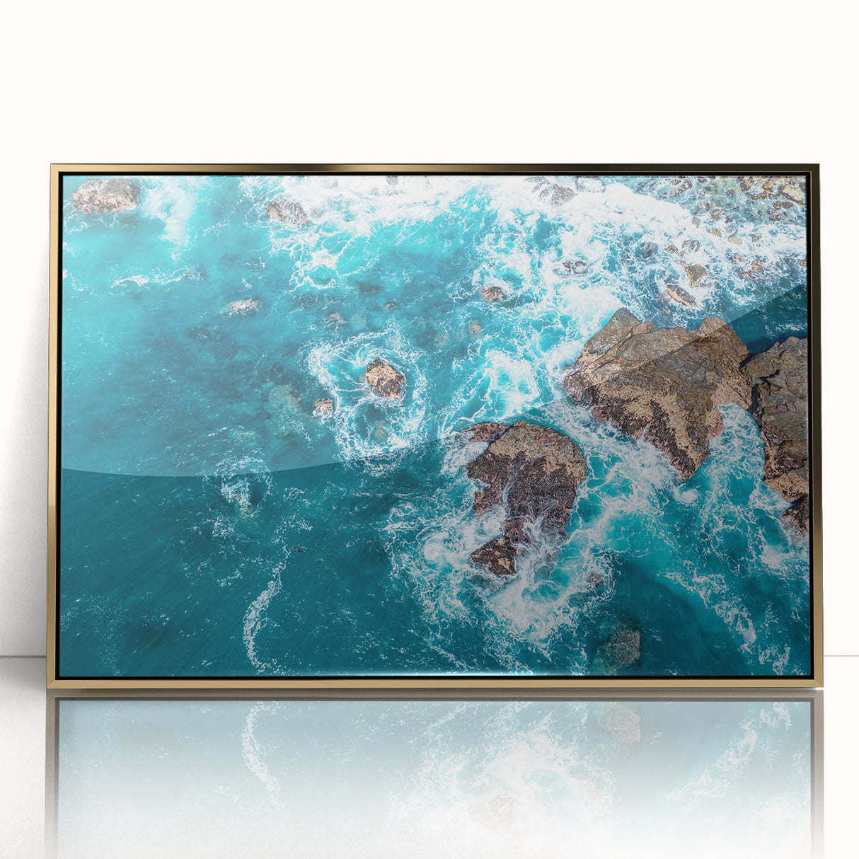 Large art print of Big Sur coastline in muted earth tones, framed in gold acrylic, embodying mid-century modernist style.