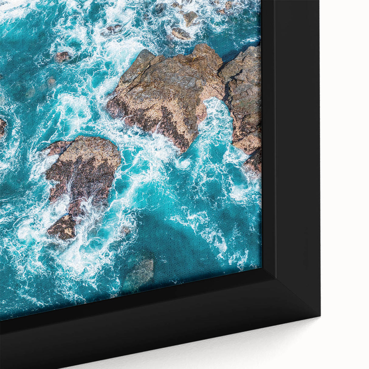 Close-up of a textured black wall art featuring a colorful Big Sur landscape on a framed canvas, ideal for living room decor.
