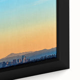 Black wall art featuring a textured depiction of the Denver skyline in colorful hues on a framed canvas.