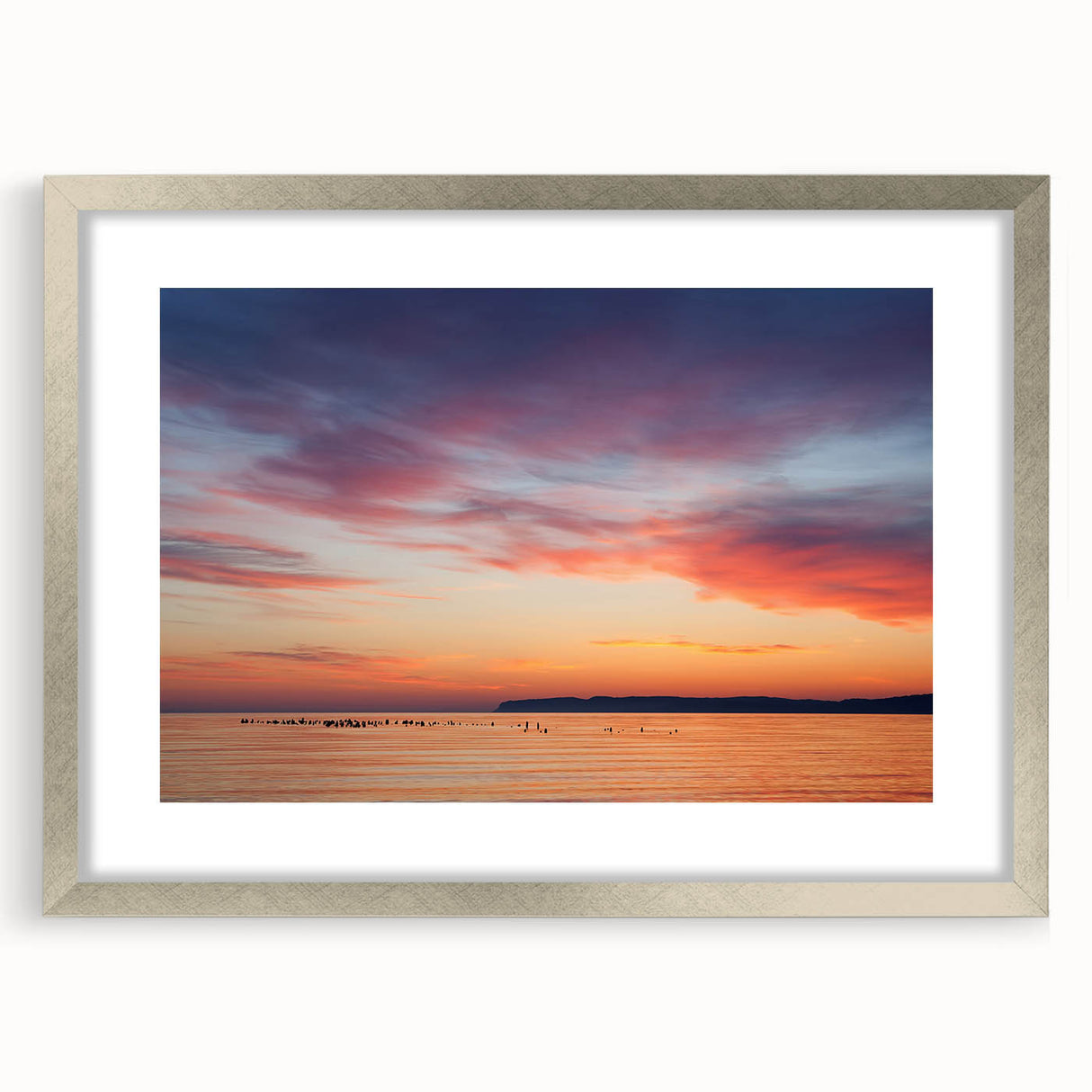 Textured art print of Lake Michigan, featuring abstract blue and white tones on a framed silver mat, ideal for bedroom decor.