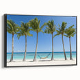 Framed landscape canvas art depicting serene beach scenery with vivid blue sky and golden sand, featuring a sleek black frame for elegant presentation.