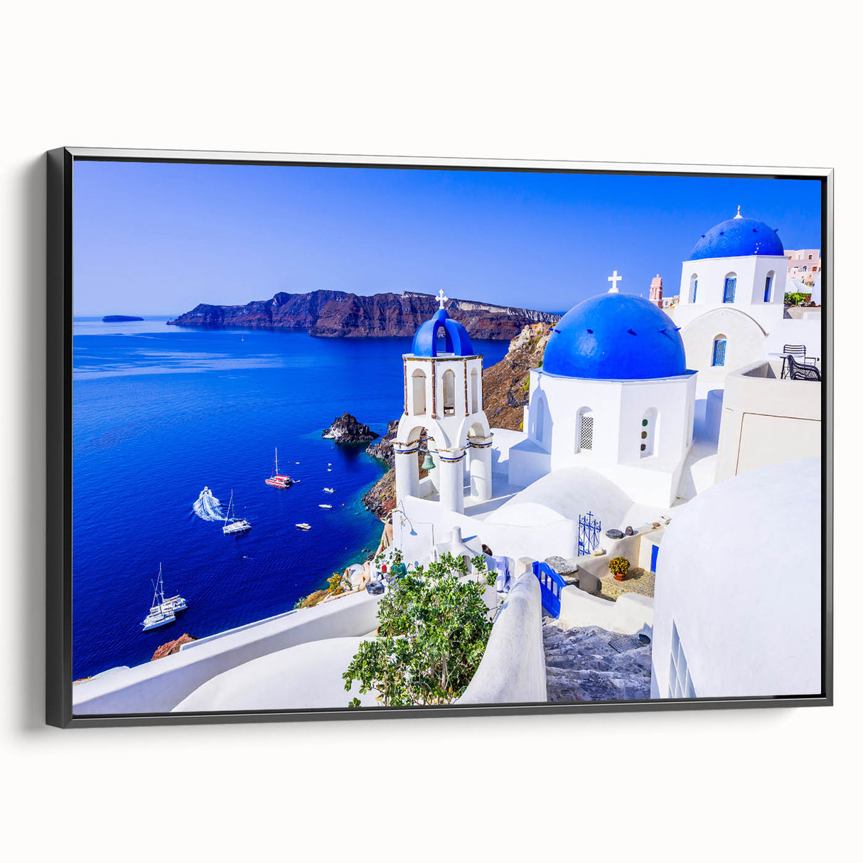 Black and white wall art featuring a vintage poster art style landscape of Santorini on framed canvas.
