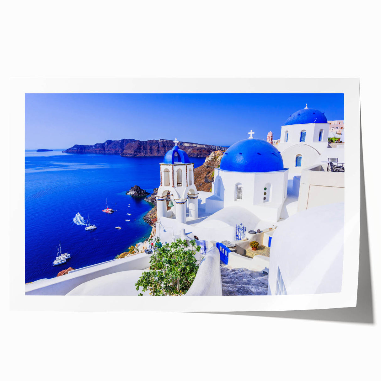 Rolled print of Santorini scenery with white buildings and blue domes against a clear sky, suitable for dining room wall art.