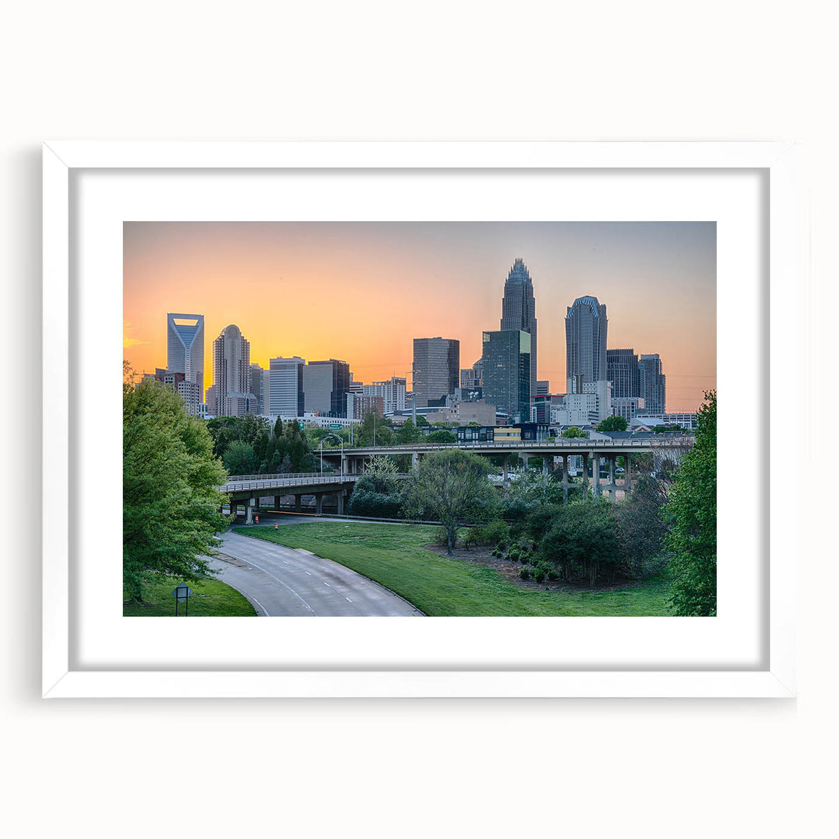 Abstract art print of Charlotte skyline in muted blue and gray tones on a framed white mat, ideal for dining room decor.