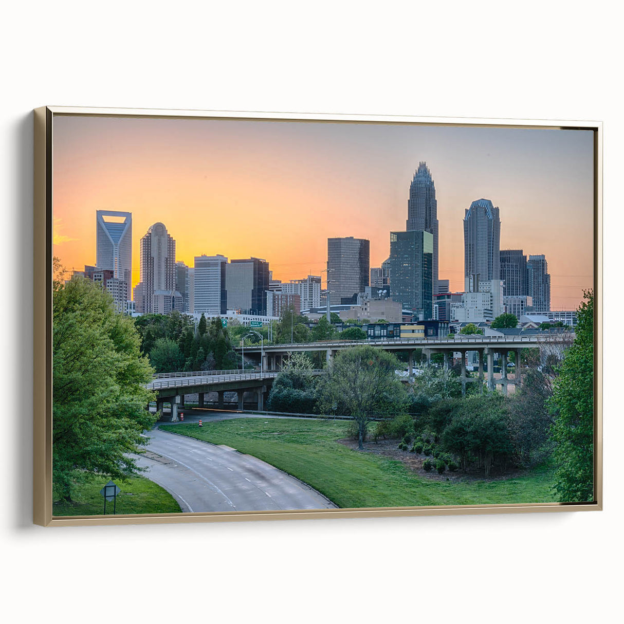 Framed canvas depicting a vintage-style Charlotte skyline in muted gold and black tones, ideal for bedroom wall art.