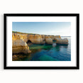 Black-framed landscape art print showcasing dramatic cliffs against a vibrant sunset, elegantly matted for a refined presentation, perfect for home decor.
