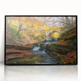Large abstract wall art depicting a European scenery in muted earth tones, framed in black acrylic.