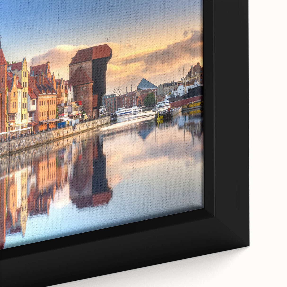 Close-up of textured black wall art featuring a vibrant, colorful European scenery on a framed canvas.