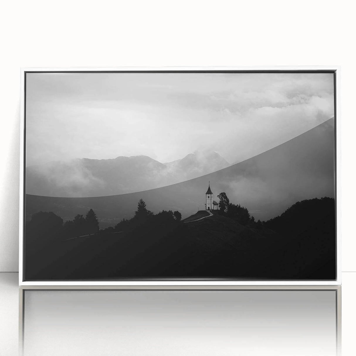 Large art print of a Slovenian landscape, featuring lush green hills under a blue sky, in a white framed acrylic.