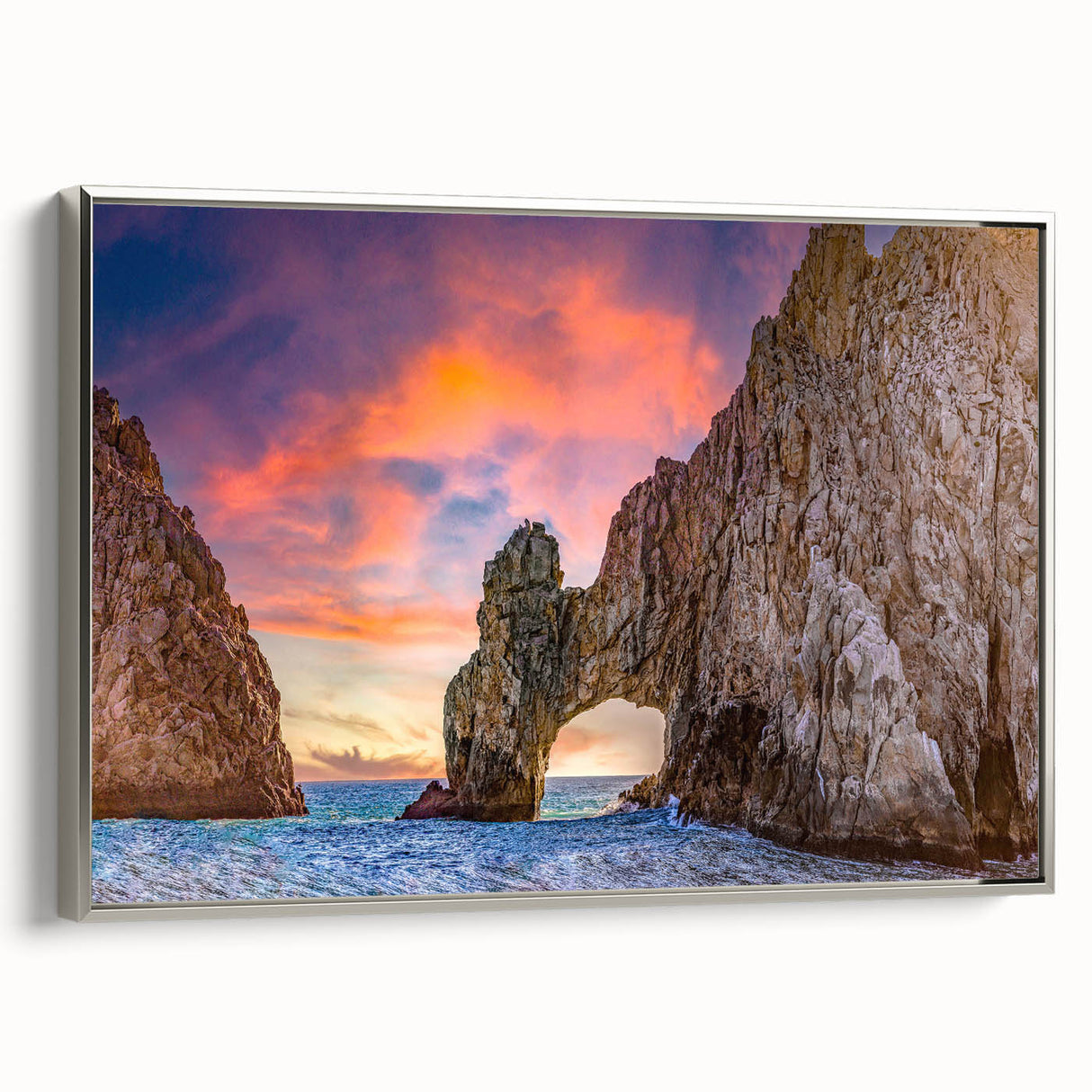 Landscape art painting of Baja California featuring colorful sky and black silhouette mountains on a silver-framed canvas.