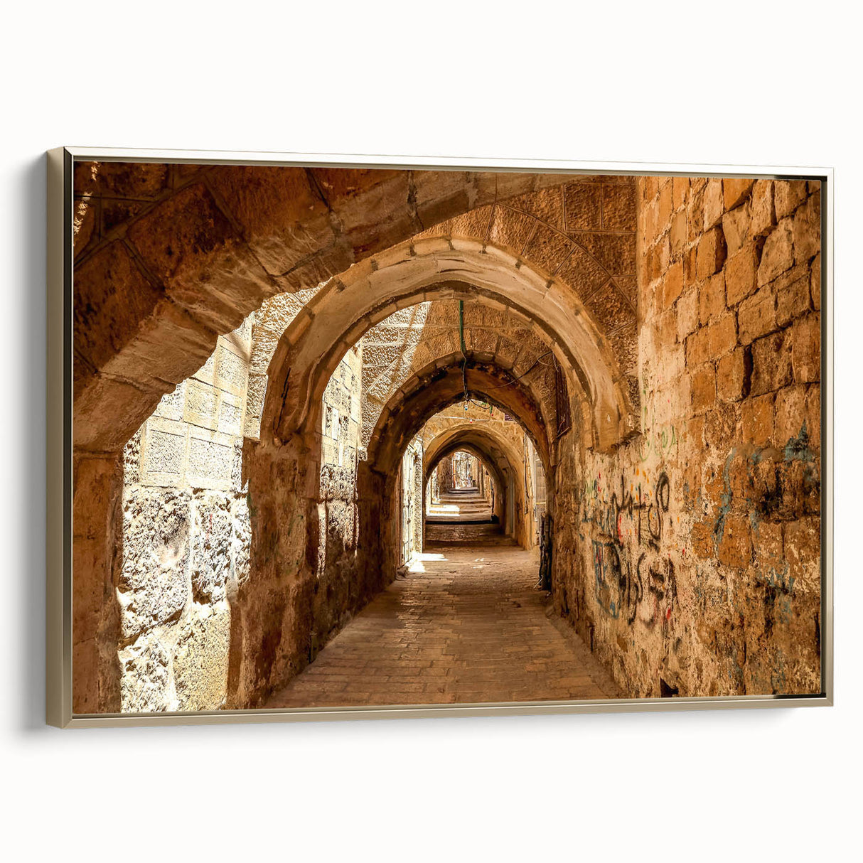 Framed canvas featuring a vintage-style landscape painting of a Middle Eastern scenery in muted gold and black tones.