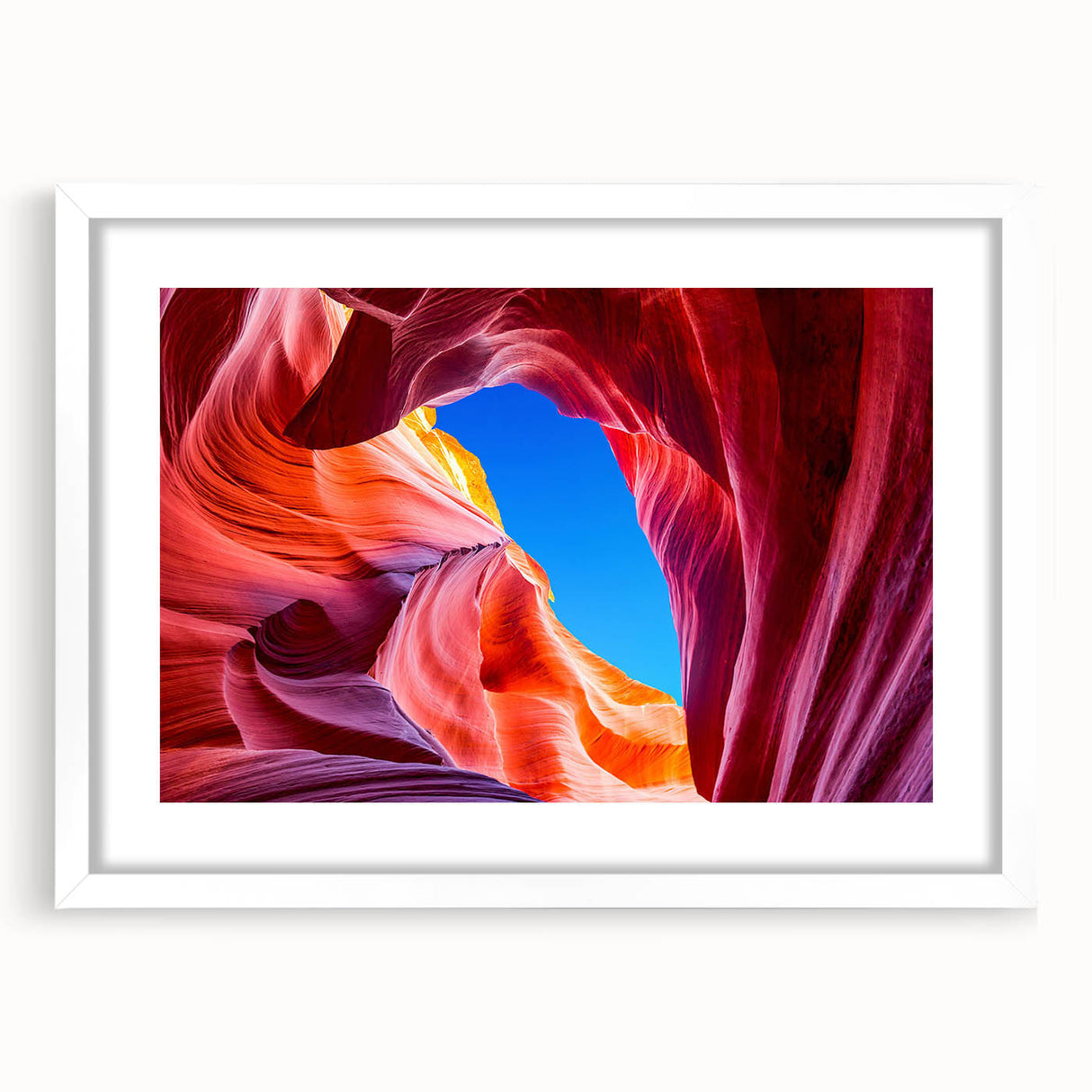 Abstract art print of Antelope Canyon in Arizona, featuring swirling red and orange rock formations, in a white matted frame.