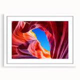 Abstract art print of Antelope Canyon in Arizona, featuring swirling red and orange rock formations, in a white matted frame.