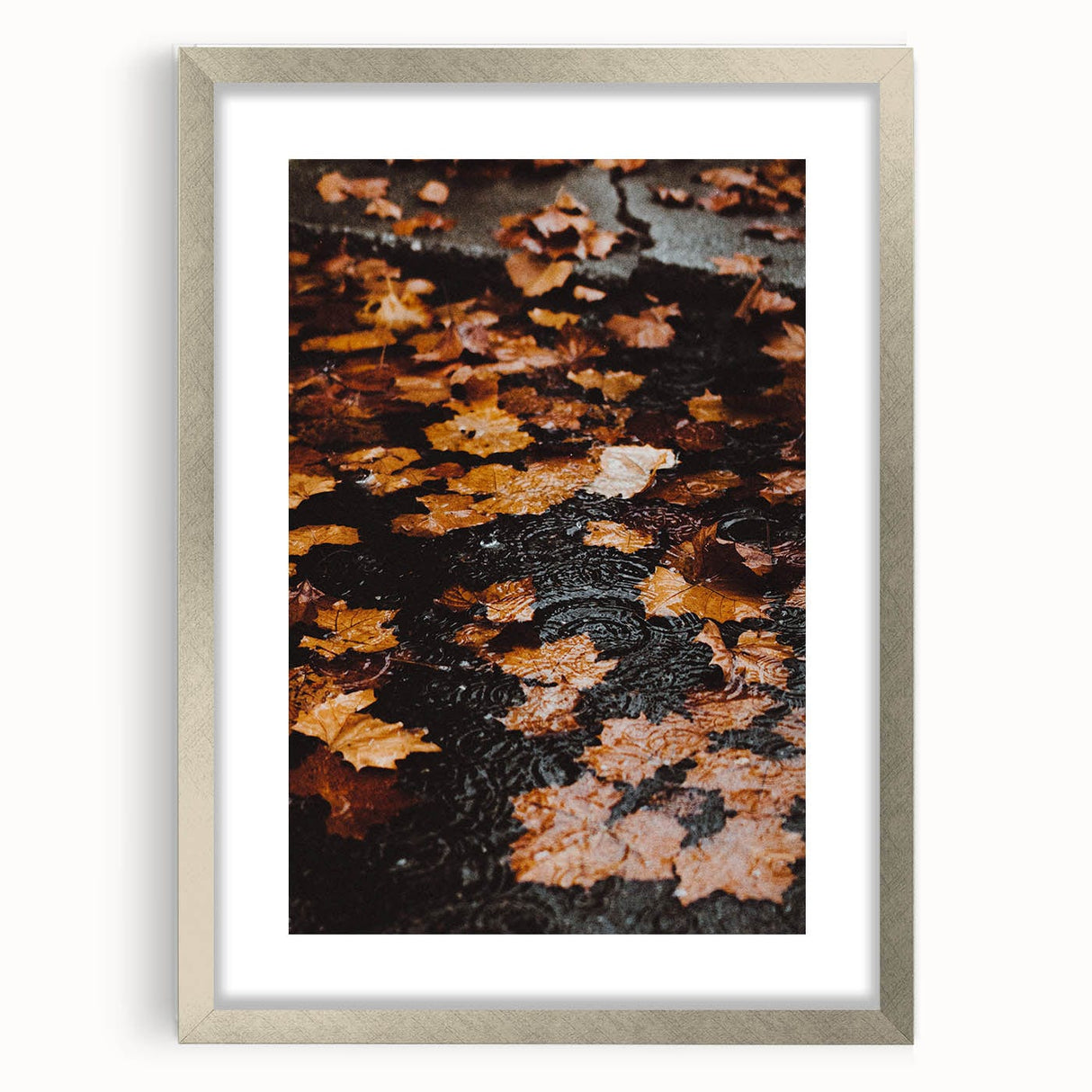 Textured abstract art print with swirls in orange and brown tones, framed in silver, suitable for bedroom decor.