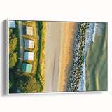 Framed canvas artwork depicting a serene beach landscape, featuring soft waves and blue skies, displayed in a sleek white frame for a modern touch. Perfect for coastal decor enthusiasts.