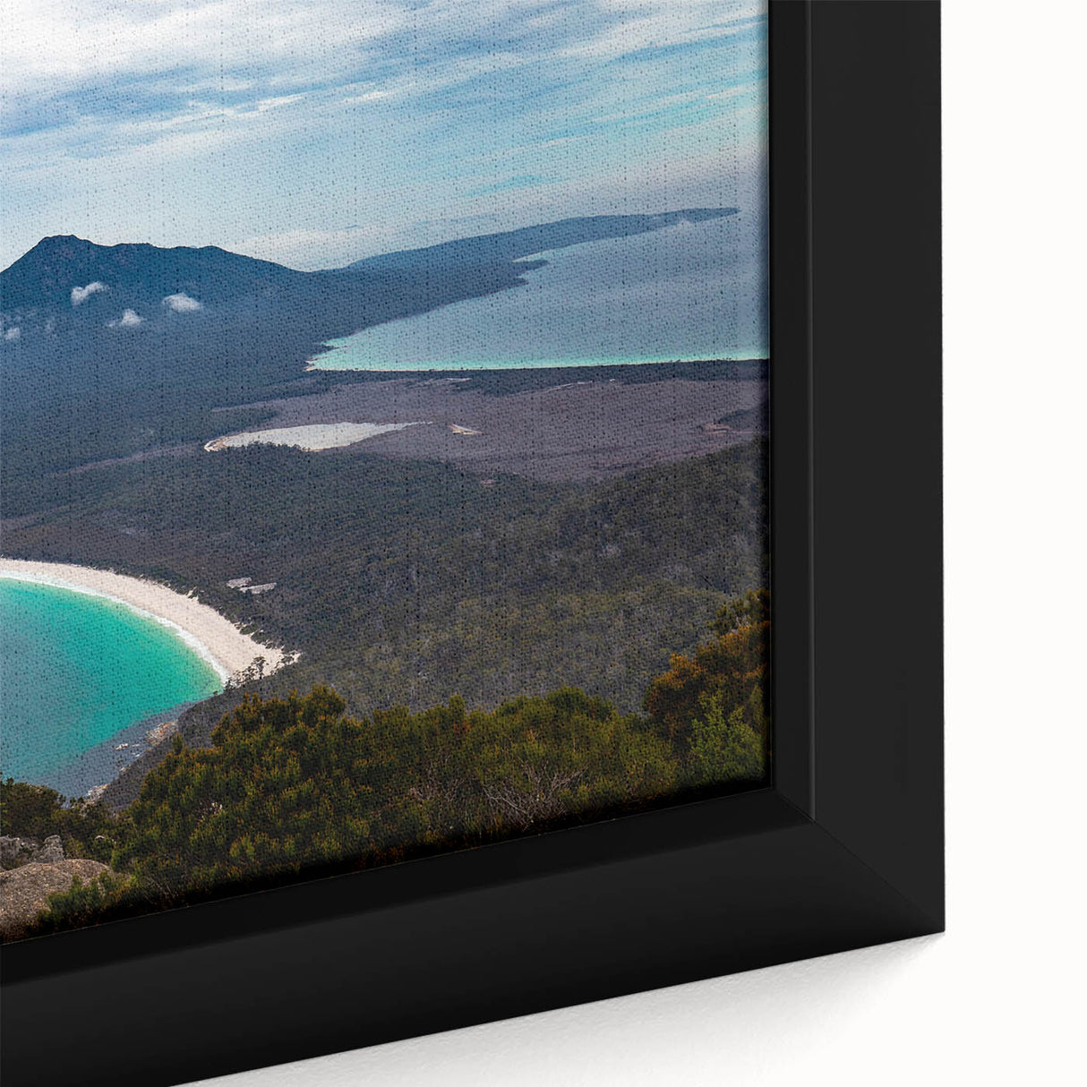 Close-up of textured black wall art featuring a colorful Tasmanian landscape on a framed canvas.