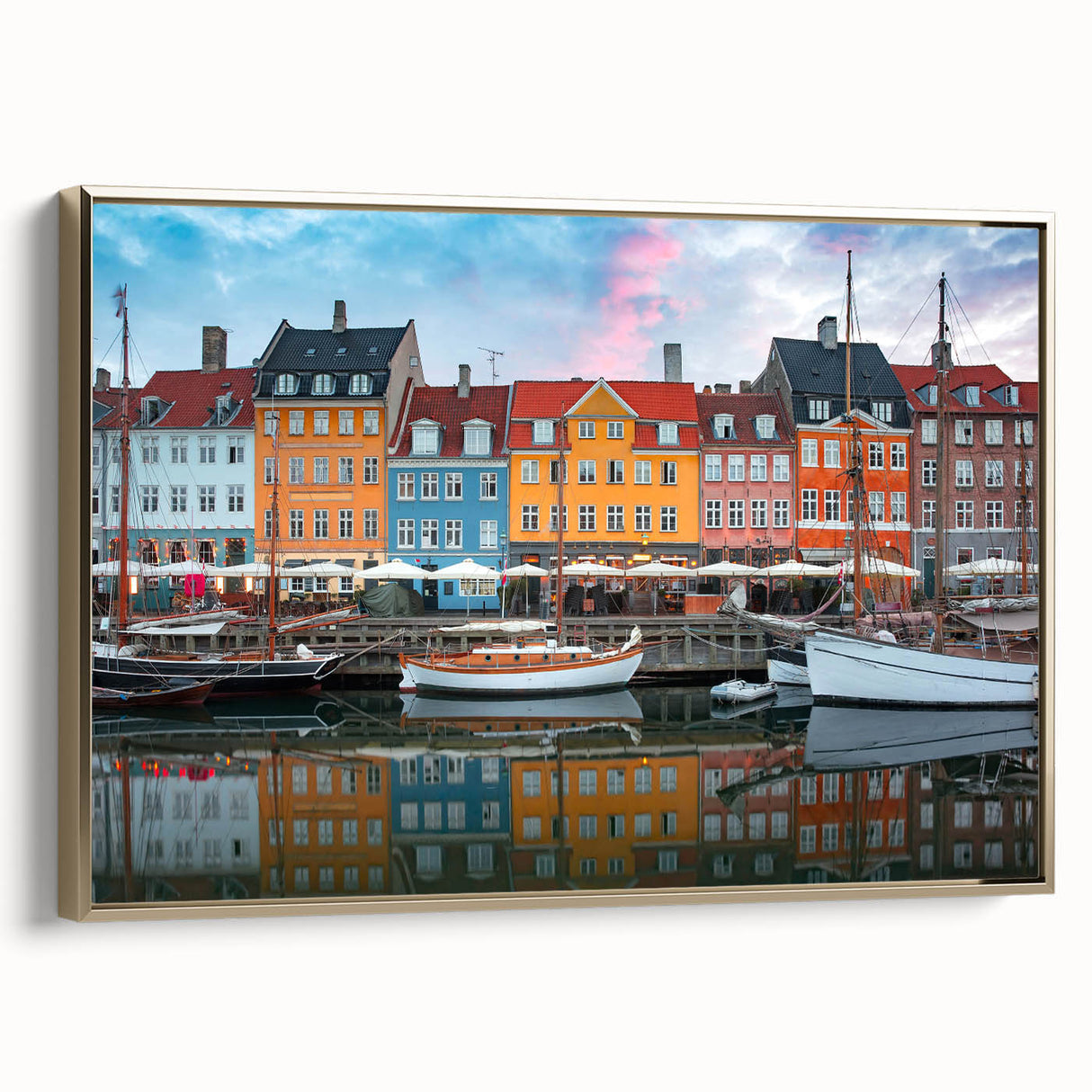 Framed canvas featuring a vintage-style landscape painting of a European scene in muted gold and black tones.