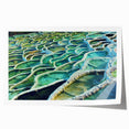 Rolled print of a European scenery featuring a floral foreground and a distant village, in soft pastel colors.
