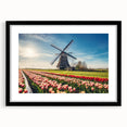 Colorful abstract art print of a European scenery in vibrant hues on a large textured canvas, framed in black.
