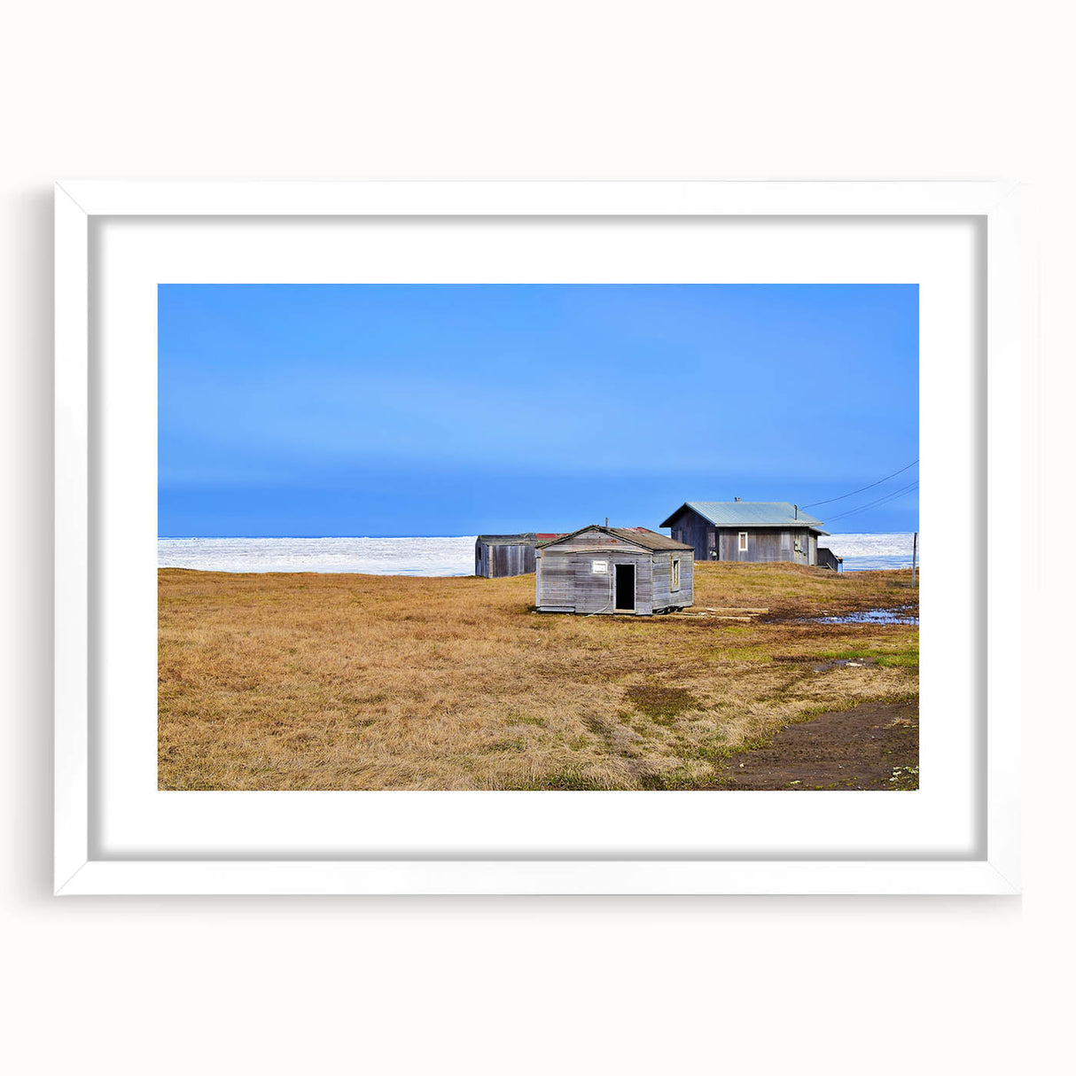 Abstract art print depicting Alaskan scenery in muted blue and gray tones on a framed white mat.