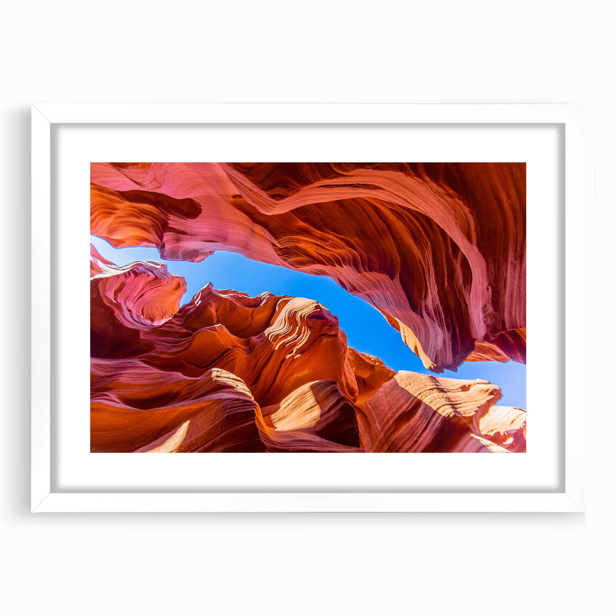 Abstract art print of Antelope Canyon in Arizona, featuring swirling orange and red sandstone patterns on a white-framed mat.