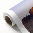 Rolled canvas artwork showcasing a vibrant landscape of rugged cliffs and serene skies, designed for wall decoration, securely packaged for delivery in a protective tube.
