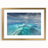 Abstract art print of a Caribbean scenery in muted blue and green tones, framed in gold, ideal for dining room decor.