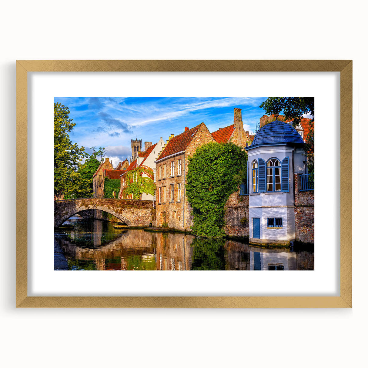 Abstract art print featuring muted gold and blue tones of a European landscape, framed with a gold mat.