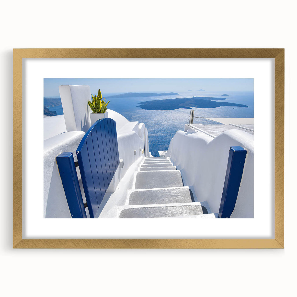 Abstract art print of Santorini with blue and white tones on a framed gold mat, suitable for dining room decor.