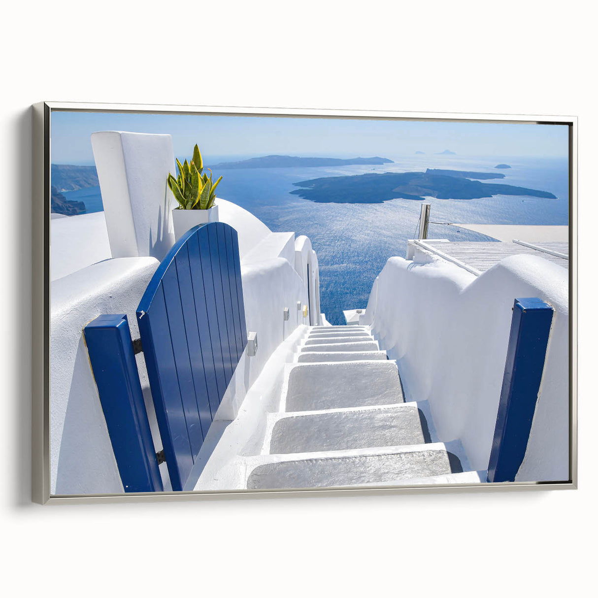 Framed canvas featuring a vintage-style landscape painting of Santorini with vivid blue and white tones.