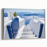 Framed canvas featuring a vintage-style landscape painting of Santorini with vivid blue and white tones.
