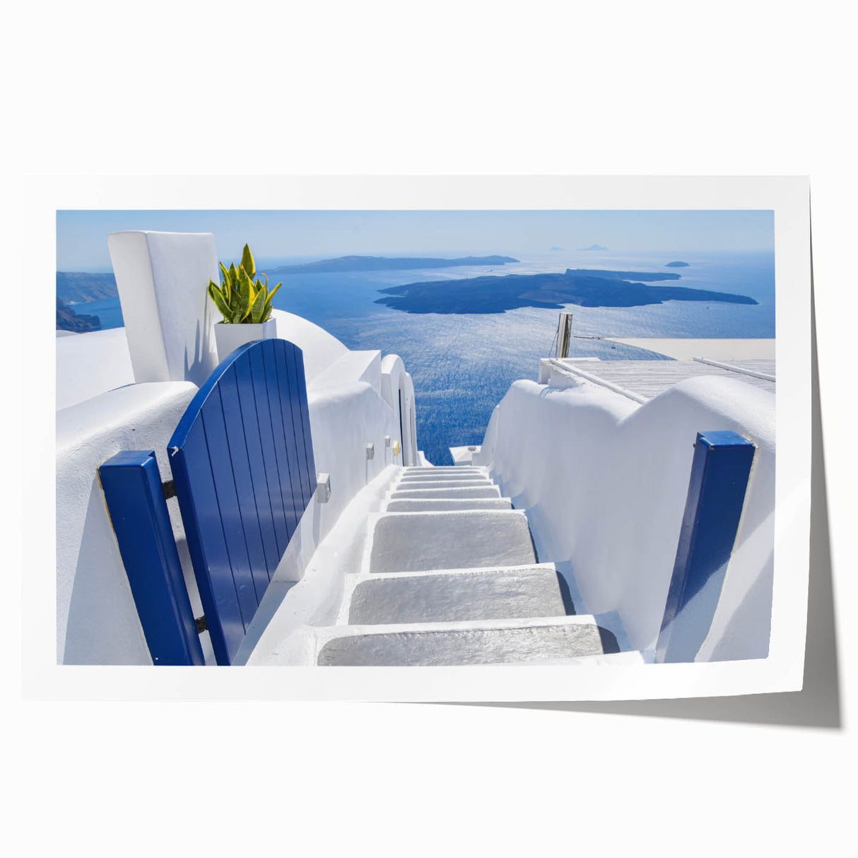 Rolled print of Santorini scenery featuring white buildings and blue domes against a clear sky.