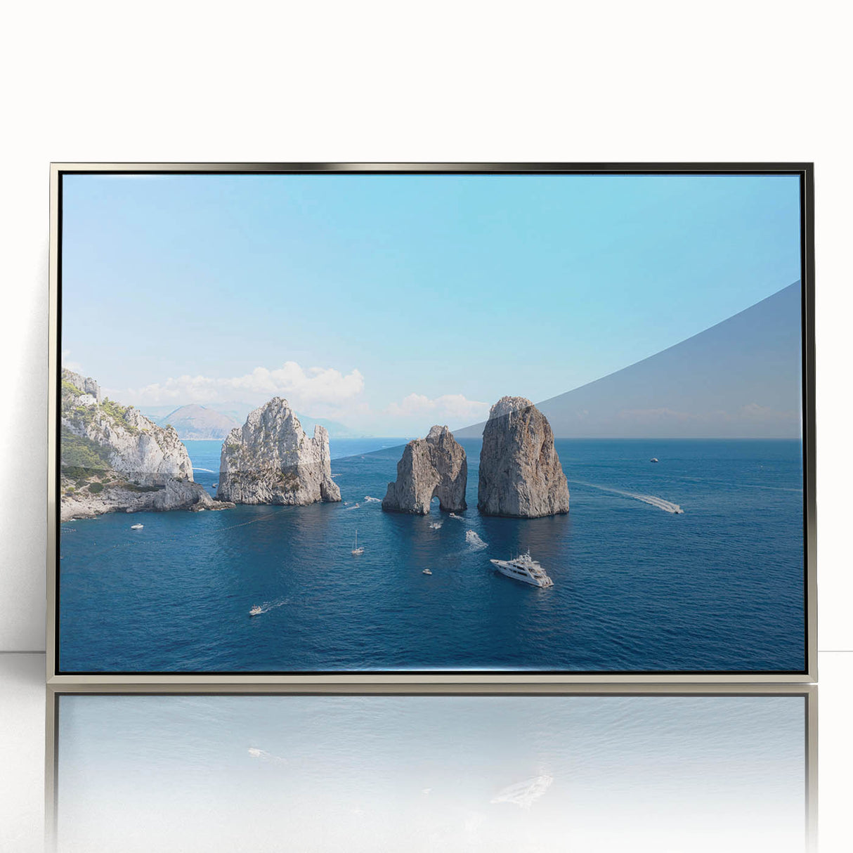 Large art print of Capri, Italy scenery in muted blue and white tones, silver-framed acrylic.