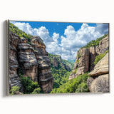 Framed canvas artwork depicting a stunning landscape with cliffs, showcasing rich colors and textures, elegantly presented with a sleek silver frame. Perfect for enhancing interior decor.