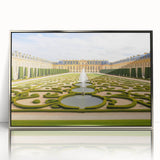 Large art print of the Versailles palace in muted gold and green tones, framed in silver acrylic.