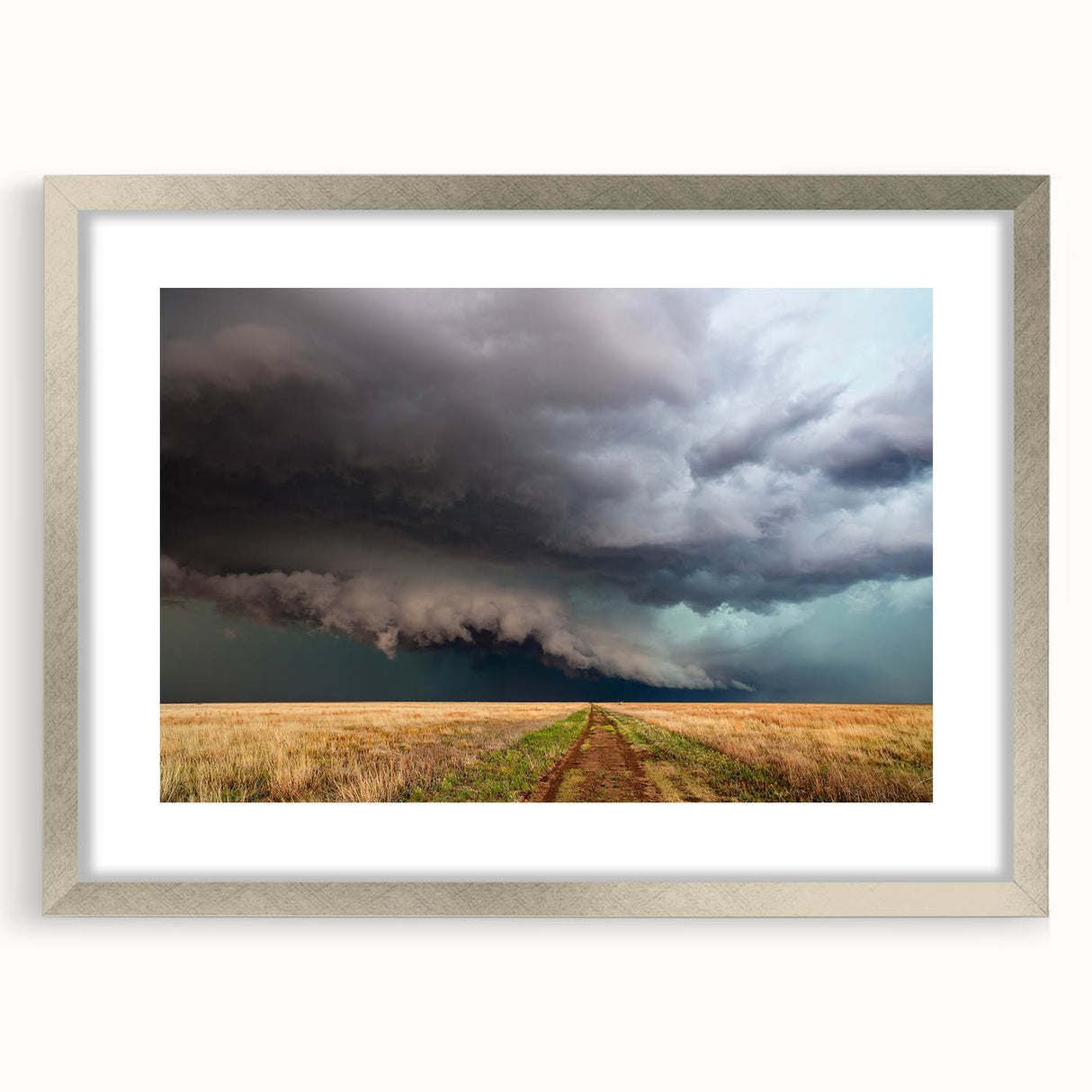 Textured art print depicting abstract Kansas scenery in muted earth tones on a framed silver mat, suitable for bedroom decor.