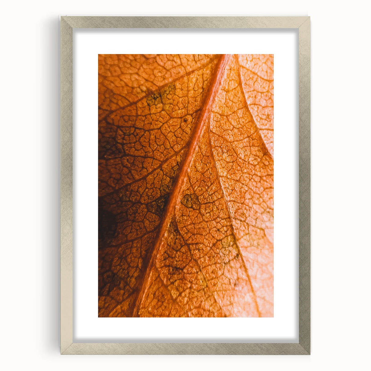 Textured abstract art print in warm orange and brown hues, framed with a silver mat, suitable for bedroom art.