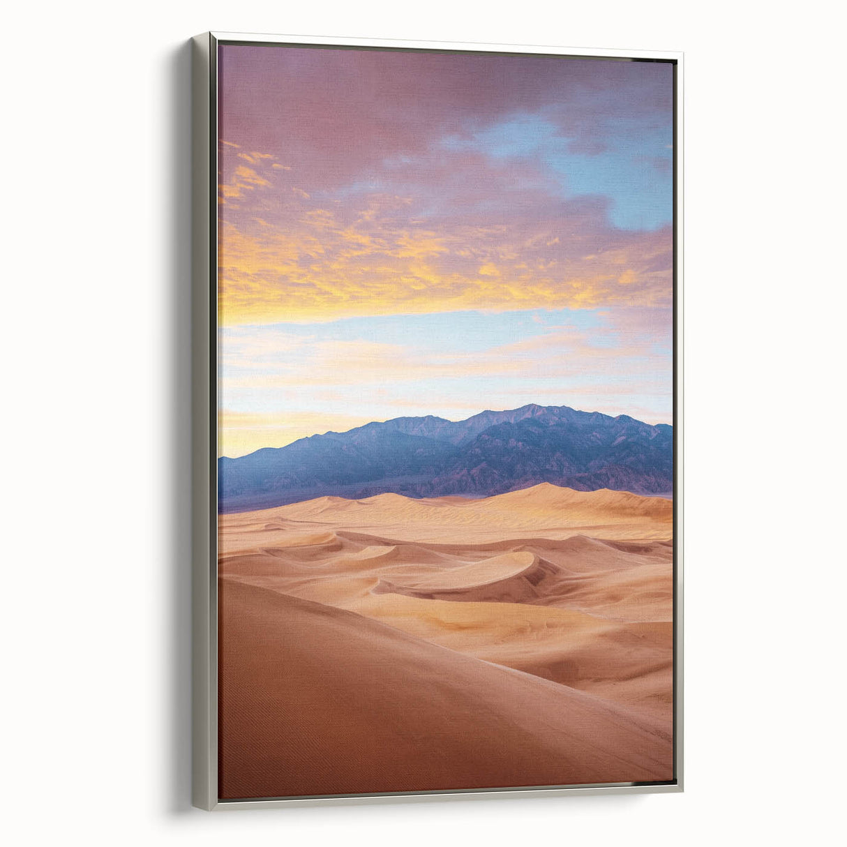 Framed canvas art depicting serene sand dunes in soft beige and gold tones. The artwork features a sleek silver frame, enhancing modern decor aesthetics.
