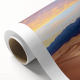 Rolled canvas showcasing a stunning landscape of golden dunes under a clear blue sky, elegantly packaged in a protective cardboard tube, perfect for home decor.