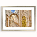 Textured abstract art print of a Tunisian landscape in earth tones on a silver-framed canvas, suitable for bedroom decor.