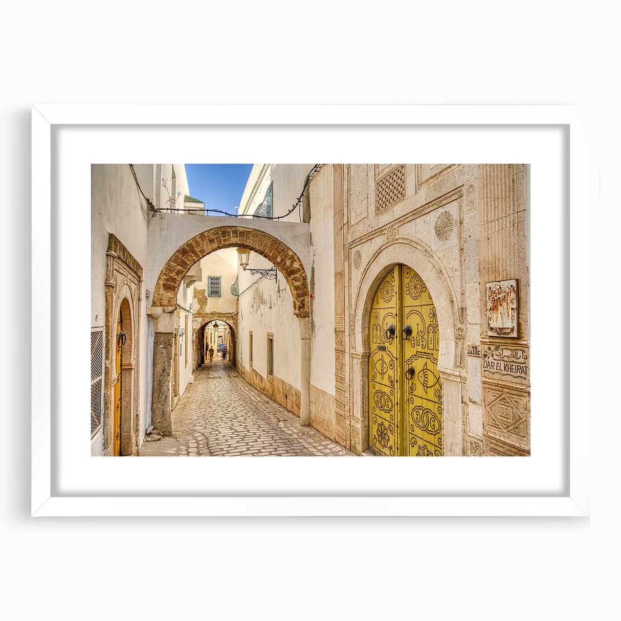 Abstract art print depicting Tunisian scenery in muted earth tones on a framed white mat.