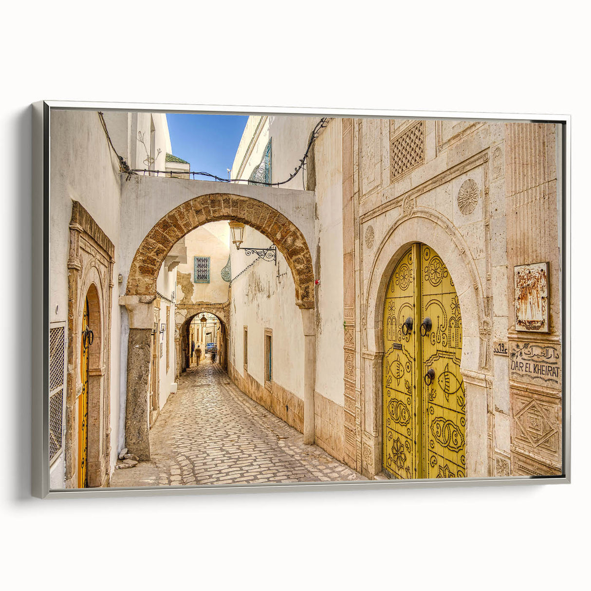 Framed canvas of a Tunisian landscape painting featuring vintage poster art style in colorful and black tones.