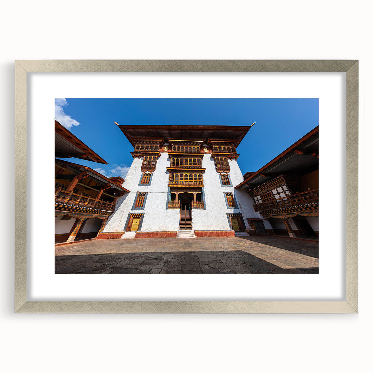 Textured art depicting an abstract Bhutanese landscape in earth tones, framed in silver, ideal for bedroom art.