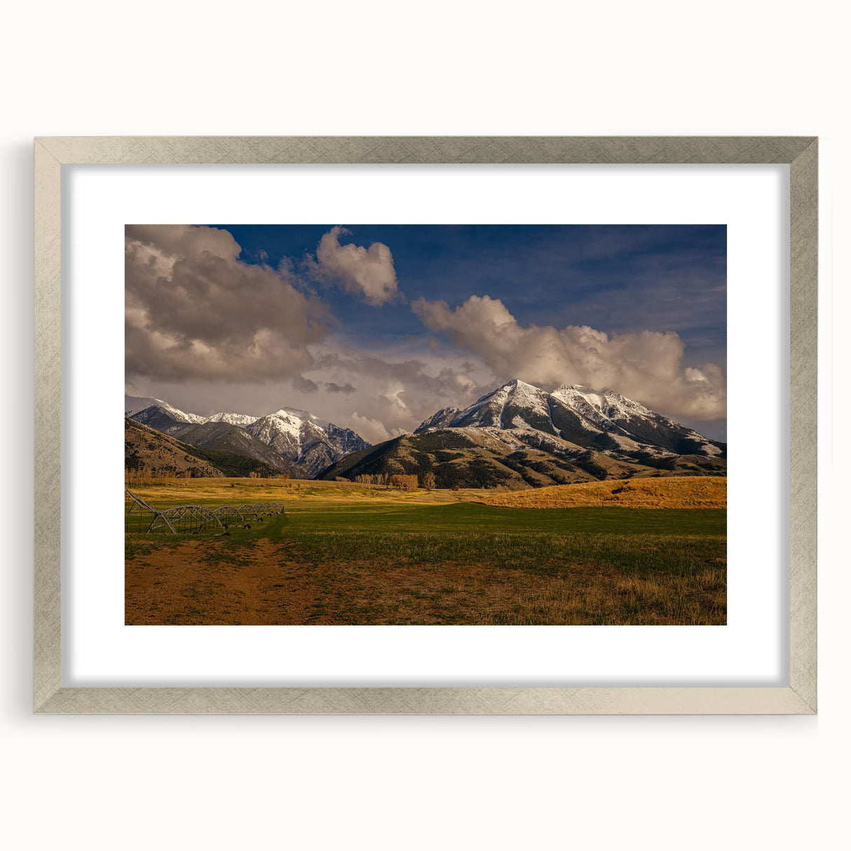 Textured abstract art print of Montana scenery in muted earth tones, framed in silver, ideal for bedroom decor.