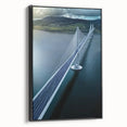 Framed canvas artwork depicting a serene landscape bridge scene, showcasing lush greenery and a tranquil waterway, set against a black frame, ideal for home decor.