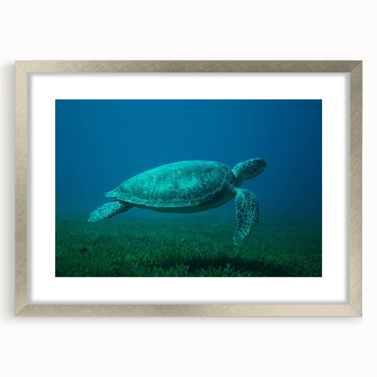 Abstract art print of a Caribbean seascape in muted blue and green tones on a framed silver mat, ideal for dining room decor.