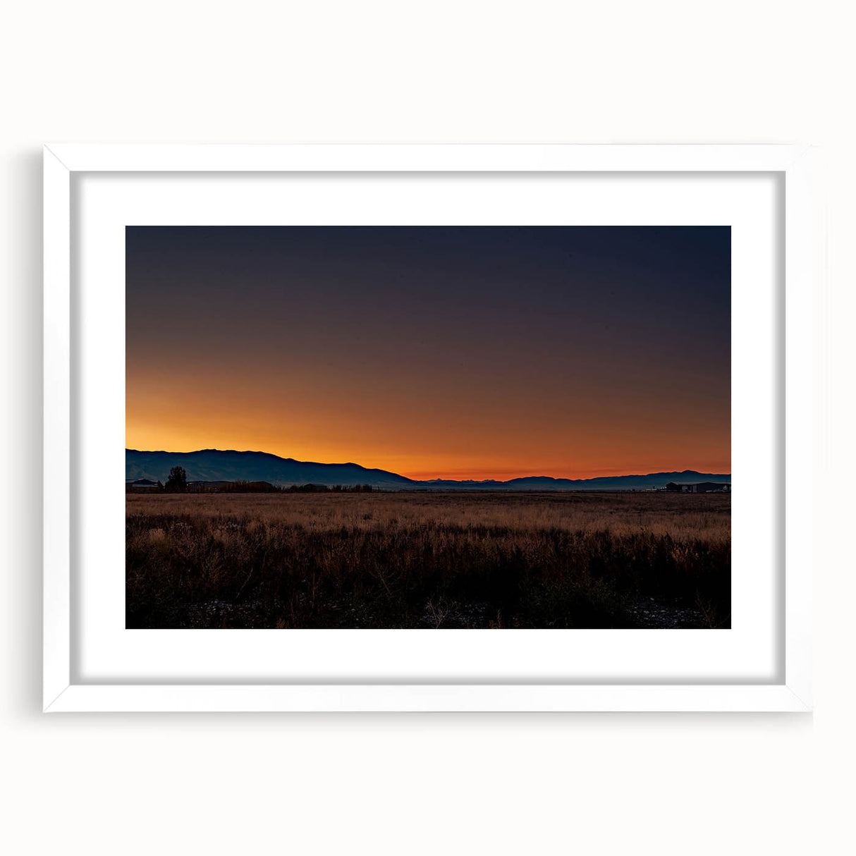 Abstract art print of Montana scenery in muted earth tones on a white matted frame, suitable for dining room decor.